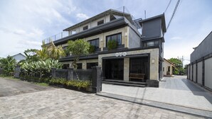 A modern two-story building with a flat roof and a large entrance.