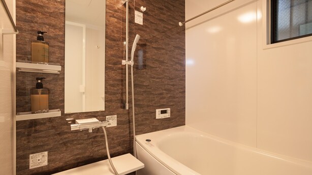 Une salle de bain moderne équipée d’une baignoire, d’une douche et d’un meuble-lavabo avec un miroir.