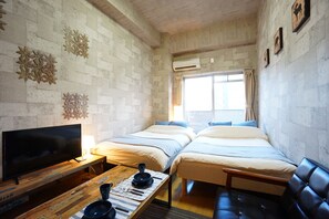 A room with two beds, a TV, a wooden table with bowls and a cup, and a window with curtains. - Terry's Apartment Namba South I V06A (Osaka)