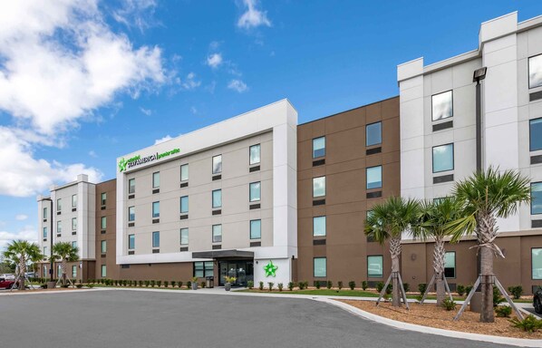 Un hotel moderno con techo plano, varios pisos y una entrada central.