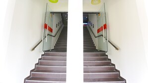 A staircase with glass railings and a red accent wall. - OYO 822 Zande Motel Kuala Selangor (Kuala Selangor)