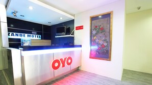 A hotel reception desk with a sign for Zande Motel and a large OYO logo. - OYO 822 Zande Motel Kuala Selangor (Kuala Selangor)