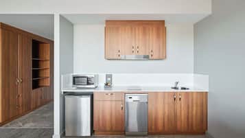 Una cocina moderna con armarios de madera, microondas, lavavajillas y un fregadero.