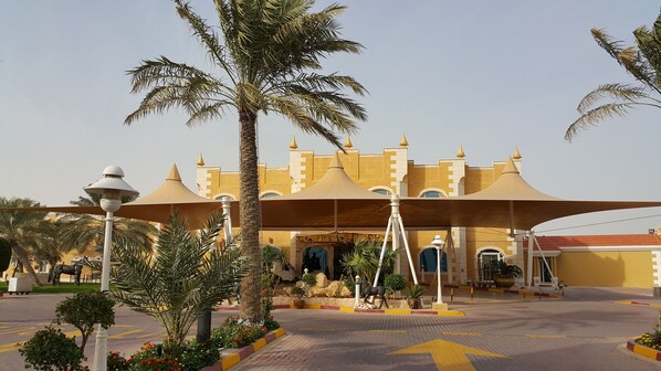 A large, castle-like building with a yellow facade and multiple towers.