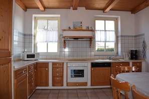 Eine Küche mit Holzausstattung, einer Mikrowelle, einem Backofen, einer Spüle und einem Fenster mit Aussicht.