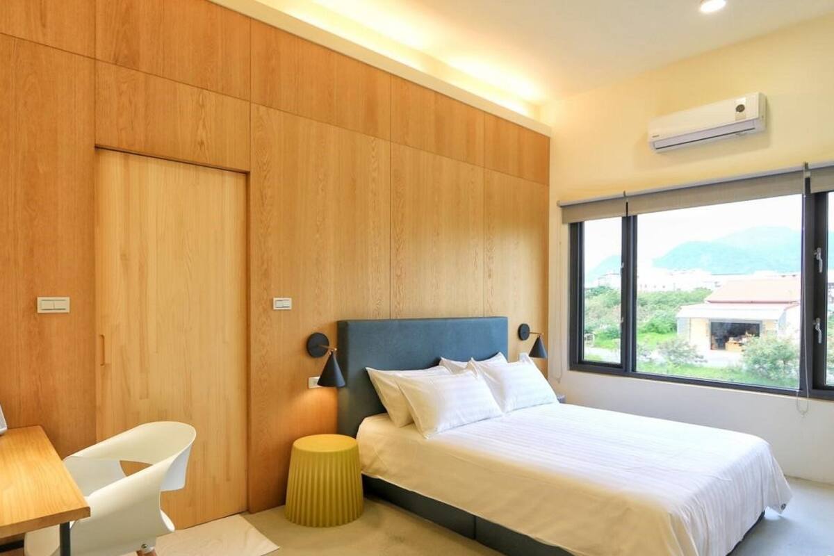 Un dormitorio moderno con una cama, un escritorio y una silla.