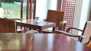 A round wooden table with two potted plants on it. - Hug Khieng Khong Nongkhai Hostel (Nong Khai)
