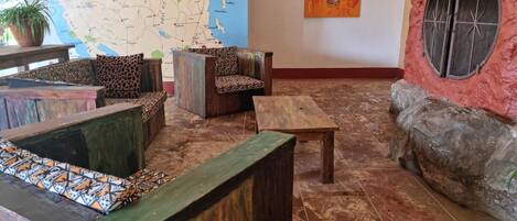 A cozy lounge area with wooden furniture and a map on the wall.