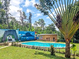 Una piscina al aire libre, sillones reclinables de piscina