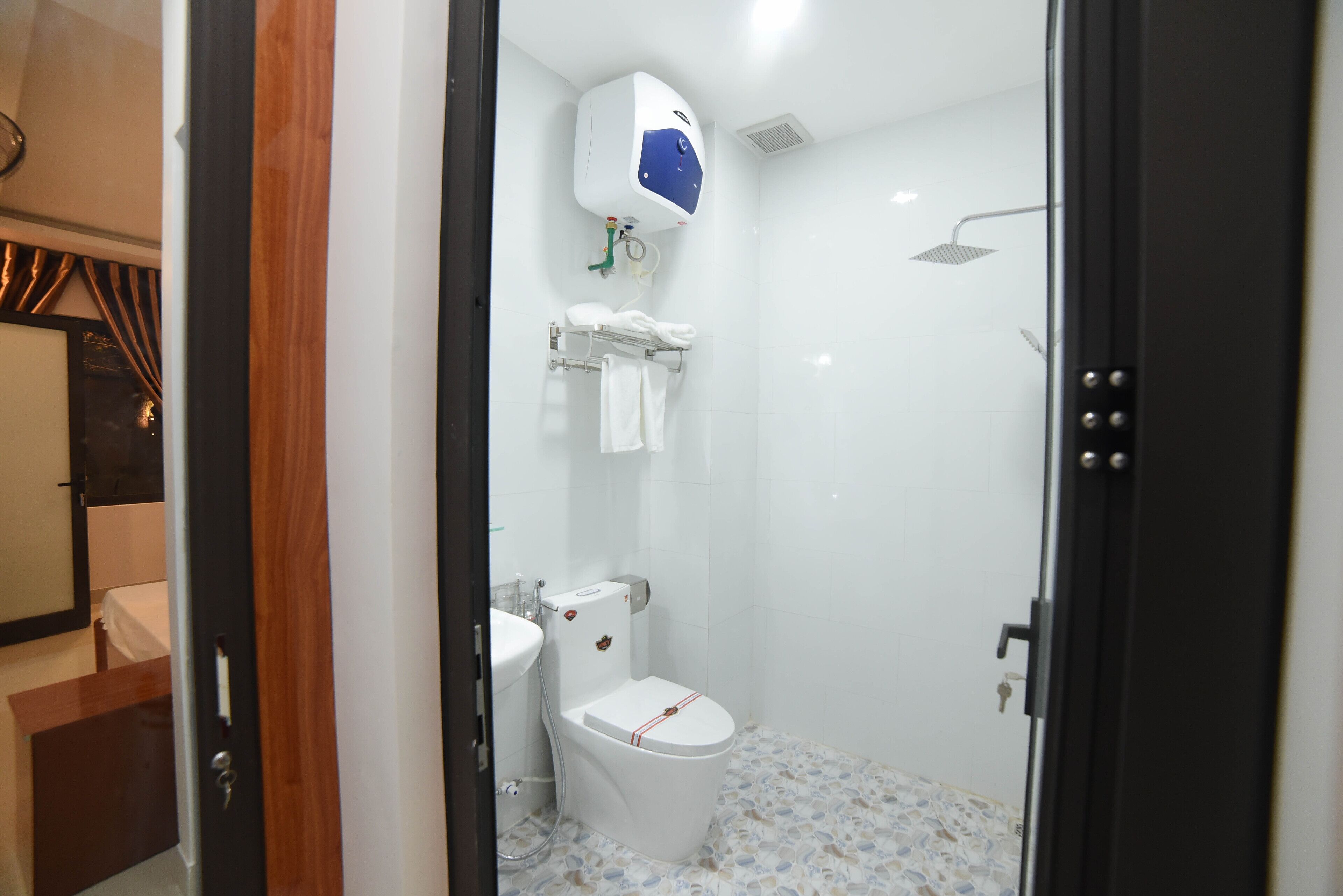 A small, modern bathroom with a toilet, sink, and shower.