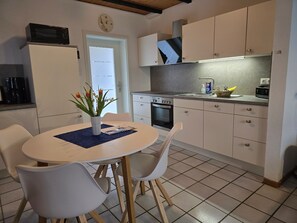 Eine moderne Küche mit weißen Schränken, einem eingebauten Backofen und einer Mikrowelle auf der Arbeitsplatte.