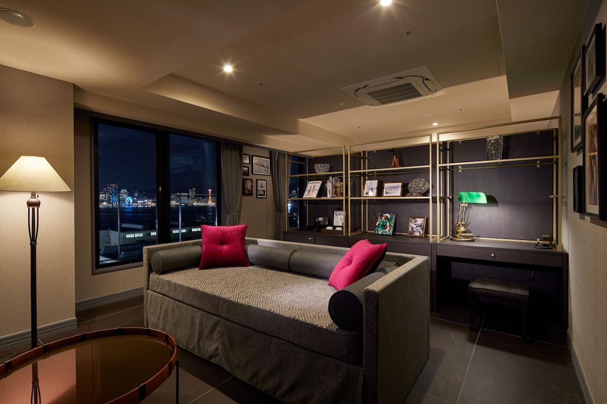 A modern living room with a sofa, a desk, and a bookshelf.