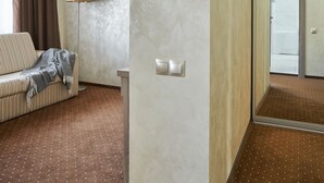 A hotel room with a sofa, a lamp, and a mirror. - Friendly Hotel (Kyiv)