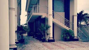 A building with a central staircase, columns, and potted plants. - Davok Suites Uyo (Uyo)