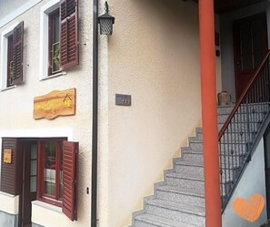 A building with a wooden sign reading "BOVECATION" and a staircase with a heart painted on the wall. - Bovecation House (Bovec)