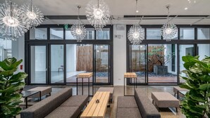 A modern interior with seating areas, large windows, and decorative lighting fixtures. - Hotel Si (Taichung)