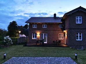 A two-story brick house with a patio and outdoor seating area.