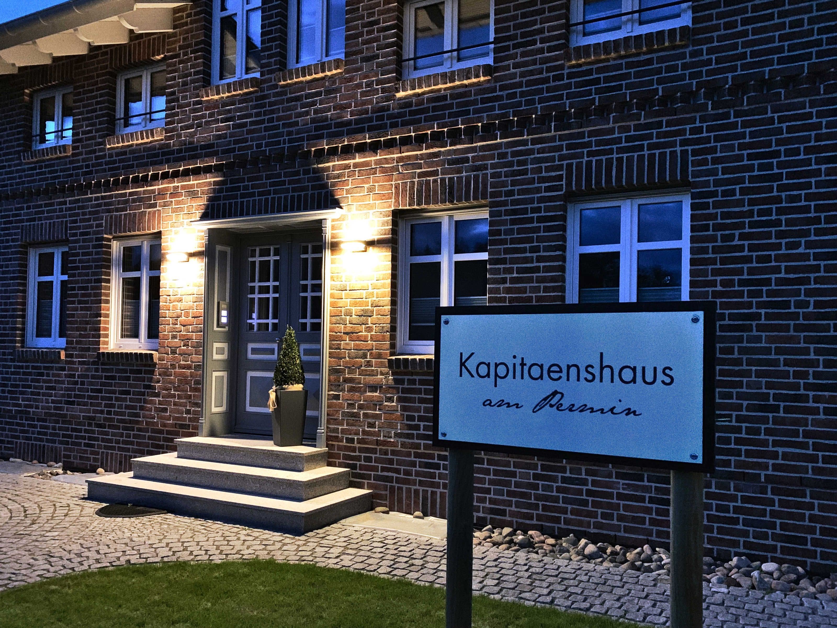 A brick building with a sign reading 'Kapitaenshaus am Persin.'