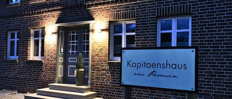 A brick building with a sign reading 'Kapitaenshaus am Persin.'