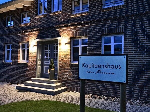 A brick building with a sign reading 'Kapitaenshaus am Persin.'