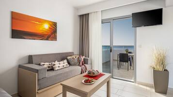 Una sala de estar moderna con un sofá, una mesa de centro y un televisor montado en la pared.