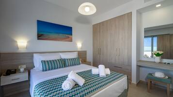 Quarto de hotel com cama, mesa de cabeceira e um espelho grande.