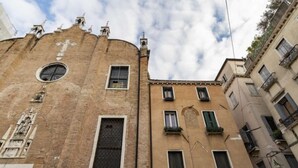 A historic building with a prominent cross, a circular window, and multiple balconies. - Rialto Sant'Aponal Prestige by Wonderful Italy (Venice)