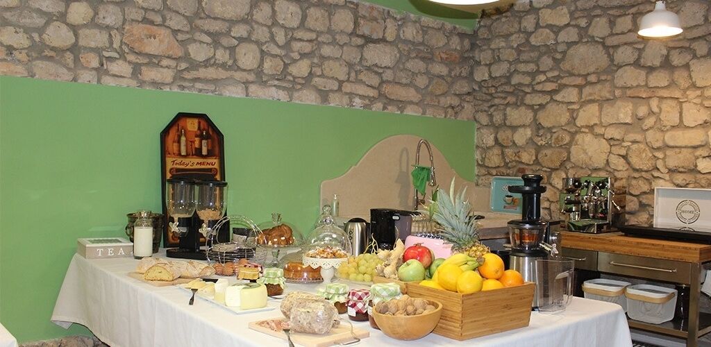 Una mesa de buffet con distintos alimentos y un reloj en la pared.