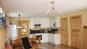 A compact living space with a dining area, kitchenette, and a cozy seating area. - Holiday Home Gamla Vägen Konga (Tingsryd)