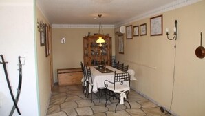 A dining area with a table set for four, a wooden cabinet, and a chandelier. - Holiday Home Gamla Vägen Konga (Tingsryd)