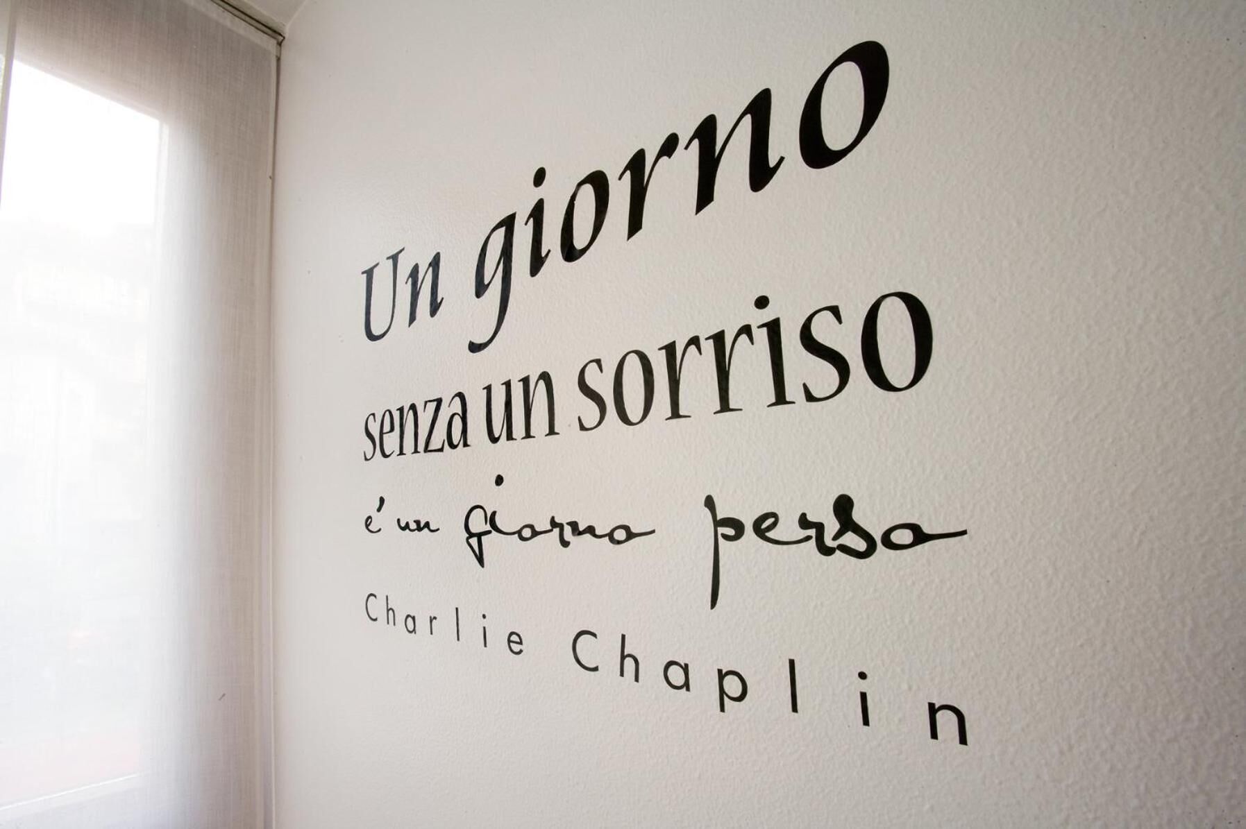 A wall with a quote in Italian by Charlie Chaplin.