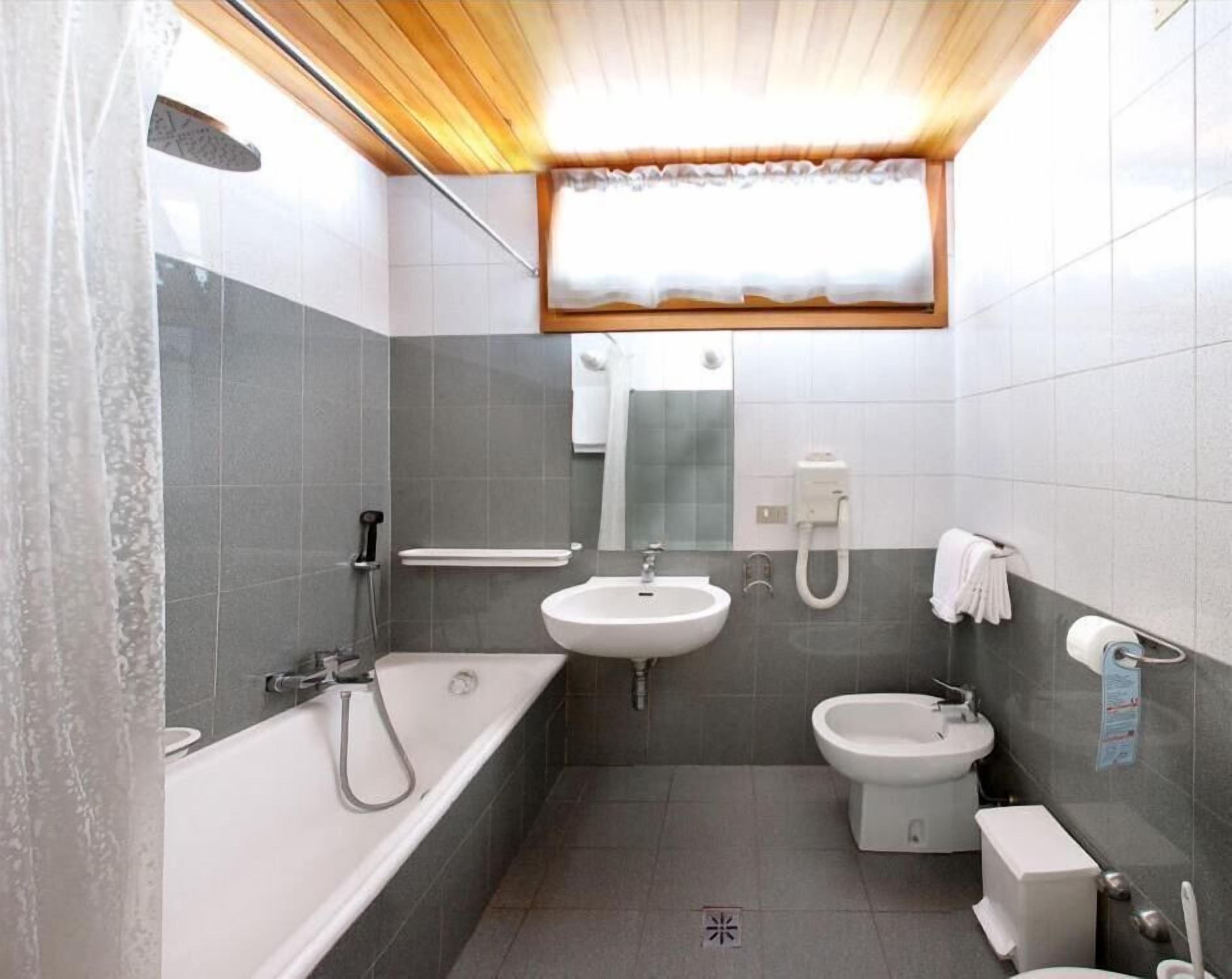 A compact bathroom with a bathtub, sink, and toilet.