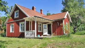 A red wooden house with a porch and a chimney. - Holiday home Törnamåla Kilen (Tingsryd)