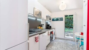 A compact kitchen with a washing machine, a microwave, and a coffee maker.