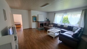 Una sala de estar con chimenea, un sofá, una mesa de centro y una televisión.