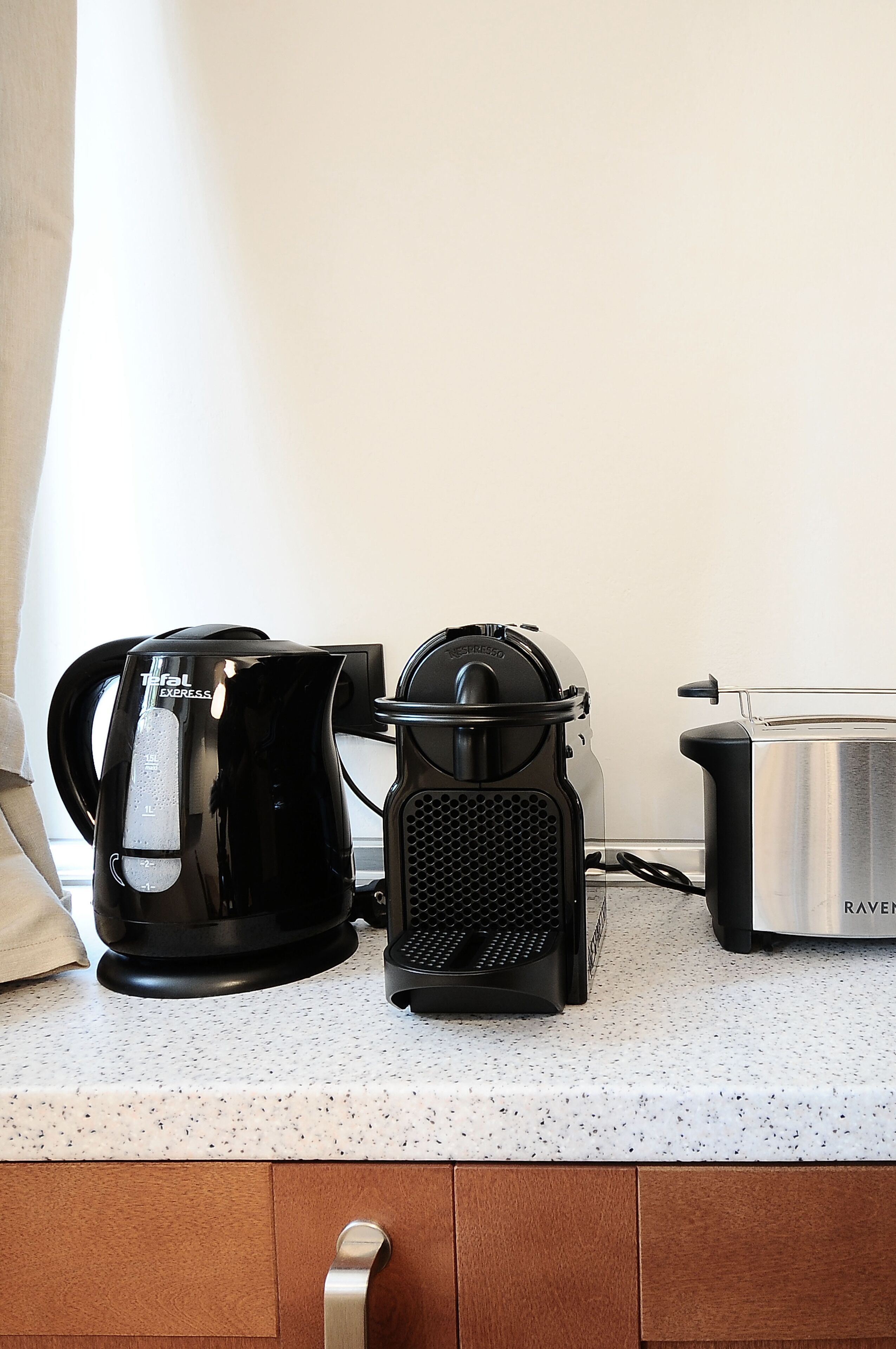 A kitchen counter with a coffee maker, a juicer, and a toaster.