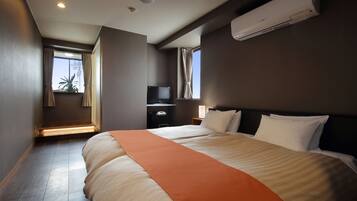 A hotel room with a large bed, a flat-screen TV, a desk, and a window with curtains.