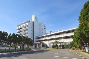 A multi-story building with a parking lot in front. - Yumemisaki (Minamiboso)