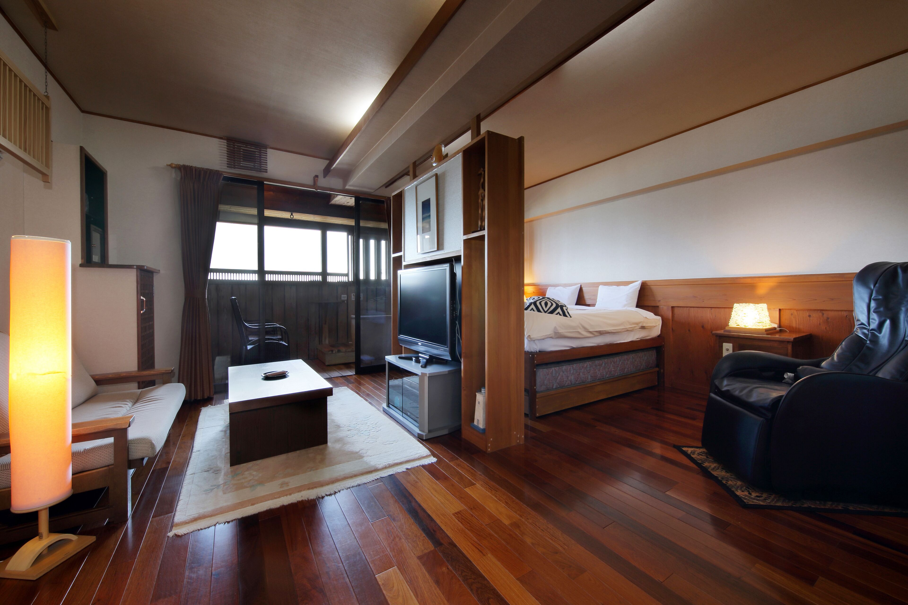 Une chambre d’hôtel équipée d’un lit, d’un bureau, d’une chaise, d’une télévision et d’un canapé.