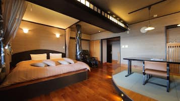 Una camera d'albergo moderna con un letto grande, un tavolino e una sedia.