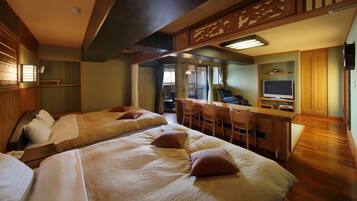 Een hotelkamer met twee bedden, een bureau met stoel, een televisie en een houten plafond.