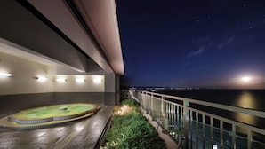 A rooftop terrace with a hot tub, a small pool, and a railing overlooking a cityscape at night. - Yumemisaki (Minamiboso)