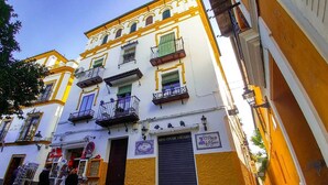 Un edificio a più piani con balconi, una vetrina chiusa e un cartello che indica 'Rincón de Fígaro'.