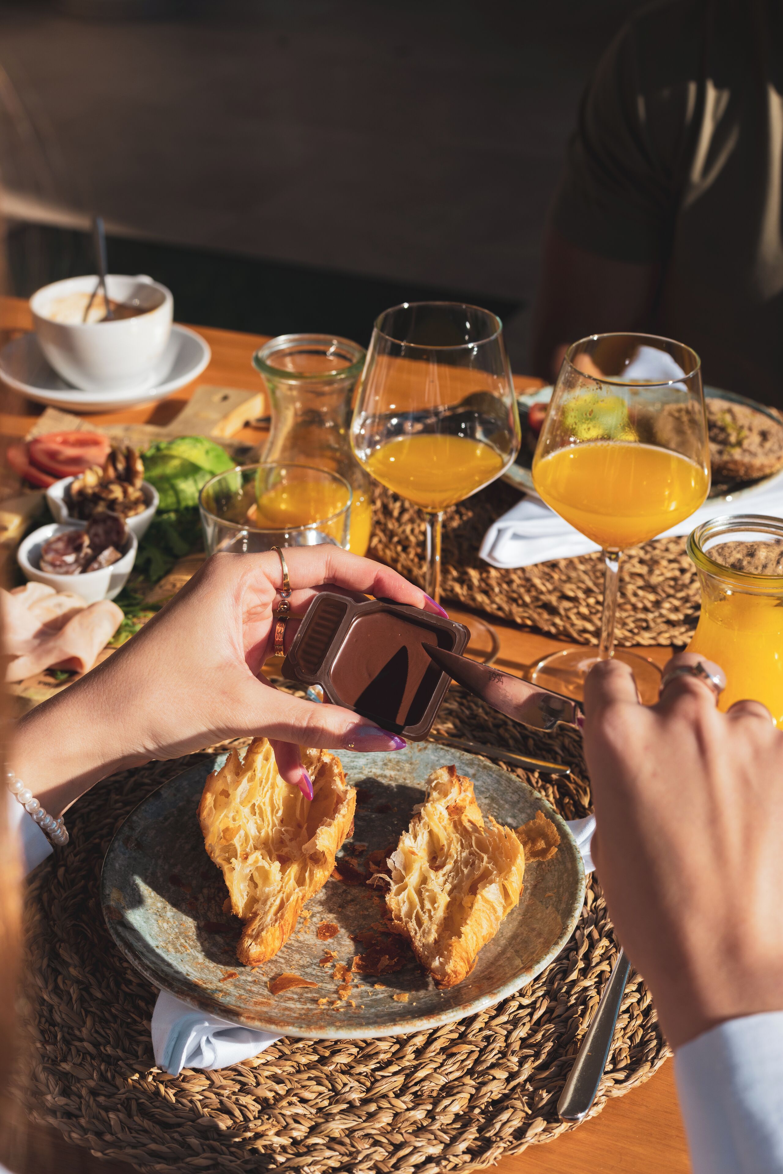 Une table mise pour le petit-déjeuner avec une assiette de toasts, un verre de jus d’orange et une tasse de café.