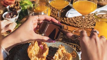Une table mise pour le petit-déjeuner avec une assiette de toasts, un verre de jus d’orange et une tasse de café.