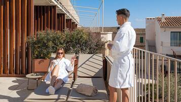 Une terrasse sur le toit avec des chaises longues, une personne debout et une femme se relaxant.