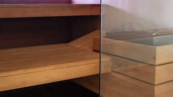 Una sauna con bancos de madera y un panel de vidrio.