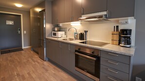 A modern kitchen with stainless steel appliances, a microwave, a coffee maker, and a sink.
