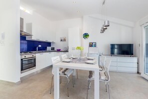 Eine moderne Küche mit weißen Schränken, einem eingebauten Backofen und einer blauen Spritzschutzwand.