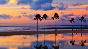 A beach scene with palm trees and a sunset. - Amazing Sunset Views, Renovated & Furnished Condo at Ilikai Hotel! (Honolulu)